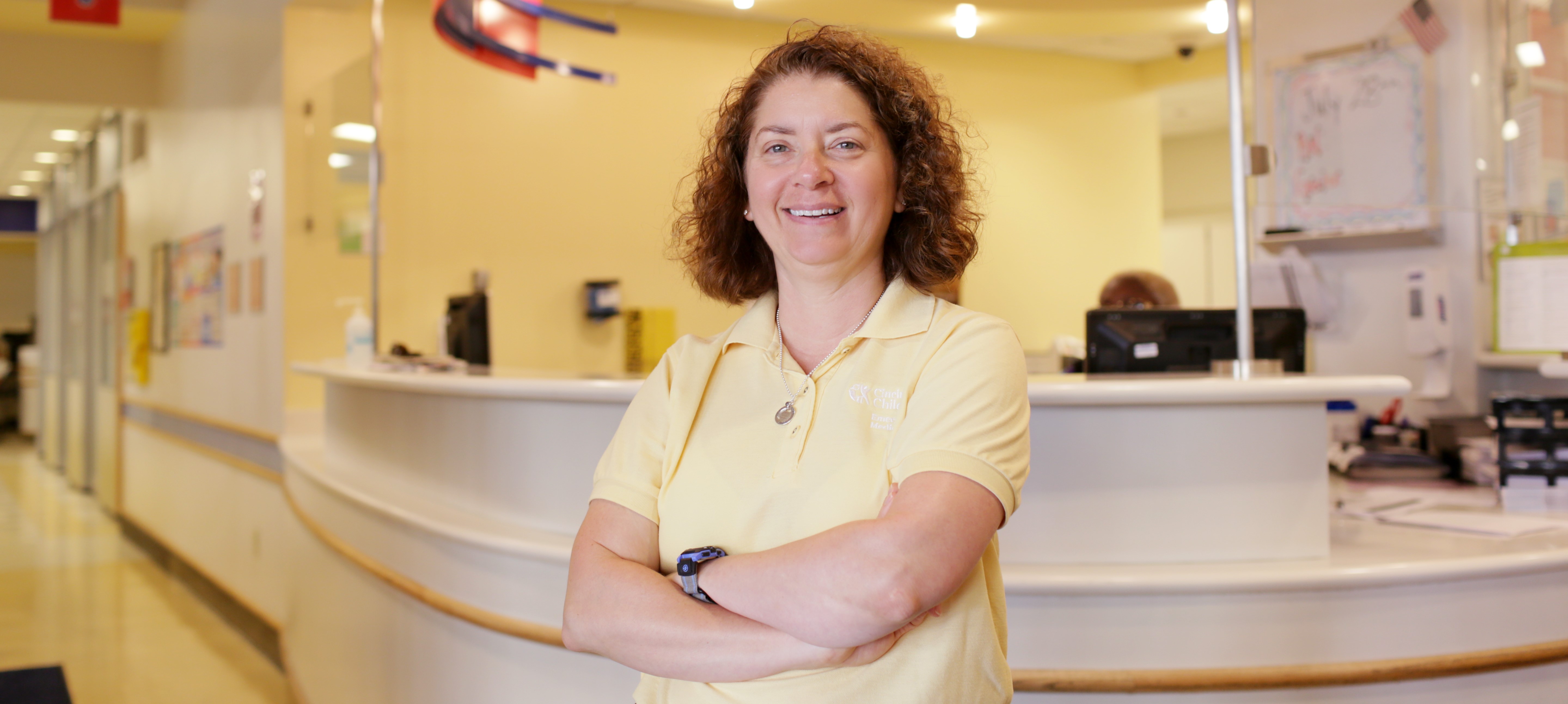 Dr. Wendy Pomeranz in yellow shirt standing in clinic reception area
