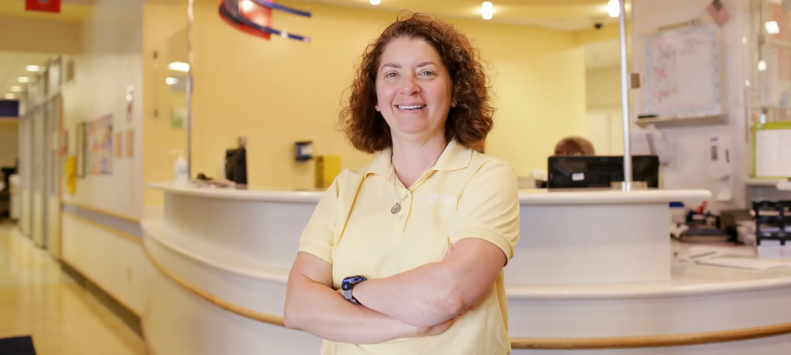 Dr. Wendy Pomeranz in yellow shirt standing in clinic reception area