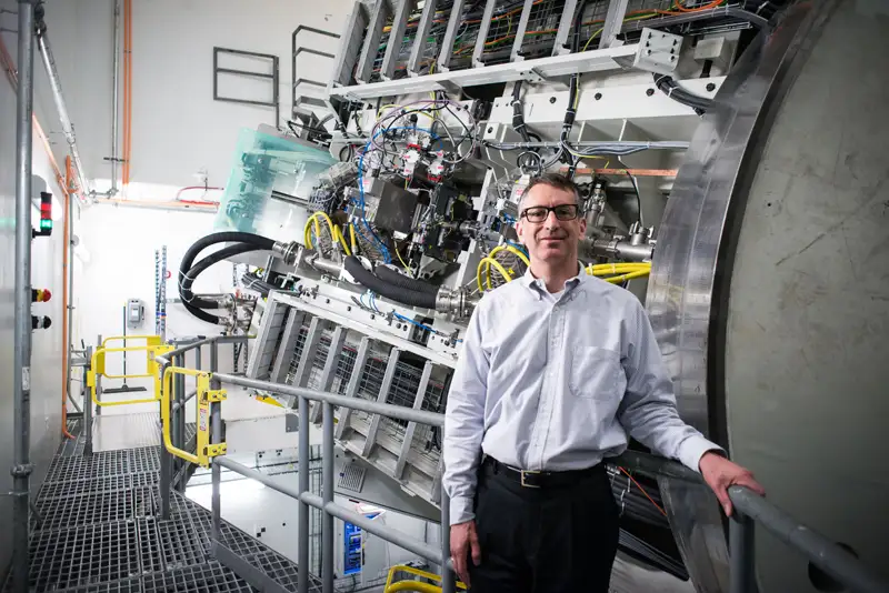 Abram Gordon stands near the complex machinery of the Proton Therapy Center at Cincinnati Children's