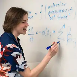Dr. Miraldi draws formulas on a whiteboard