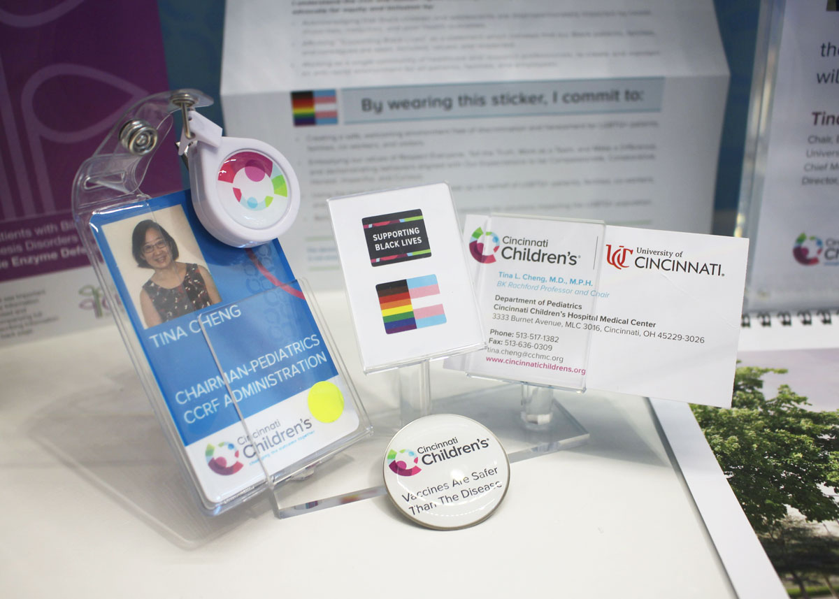 Photo of Dr. Tina Cheng's badge, business card and DEI/BLM stickers