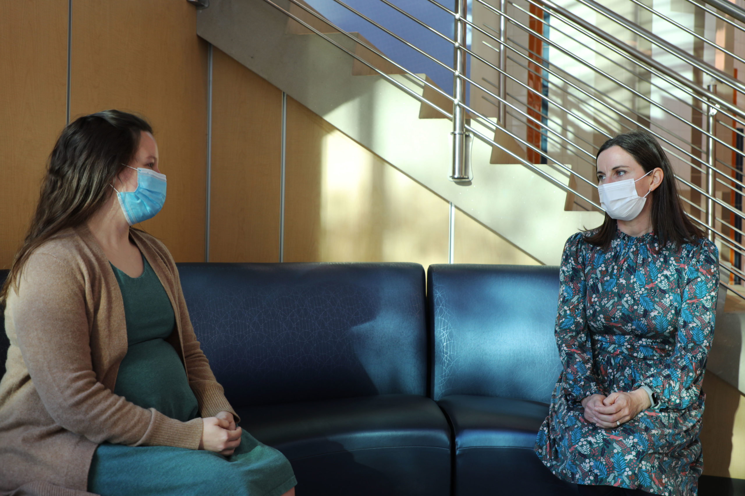 Two women wearing masks seated several feet apart. On the left, Beth, a vaccine trial participant. On the right, Dr. Schlaudecker a researcher at Cincinnati Children's