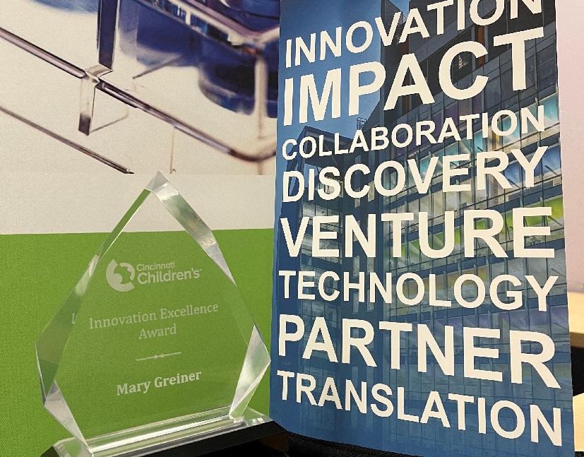 Image of crystal glass award next to poster about innovation
