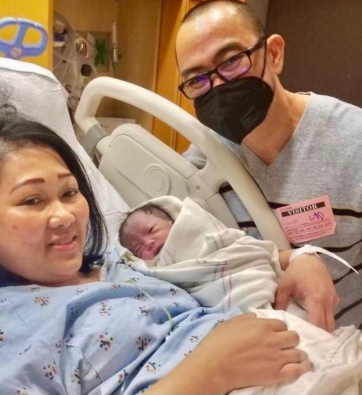 Parents holding newborn in hospital setting.