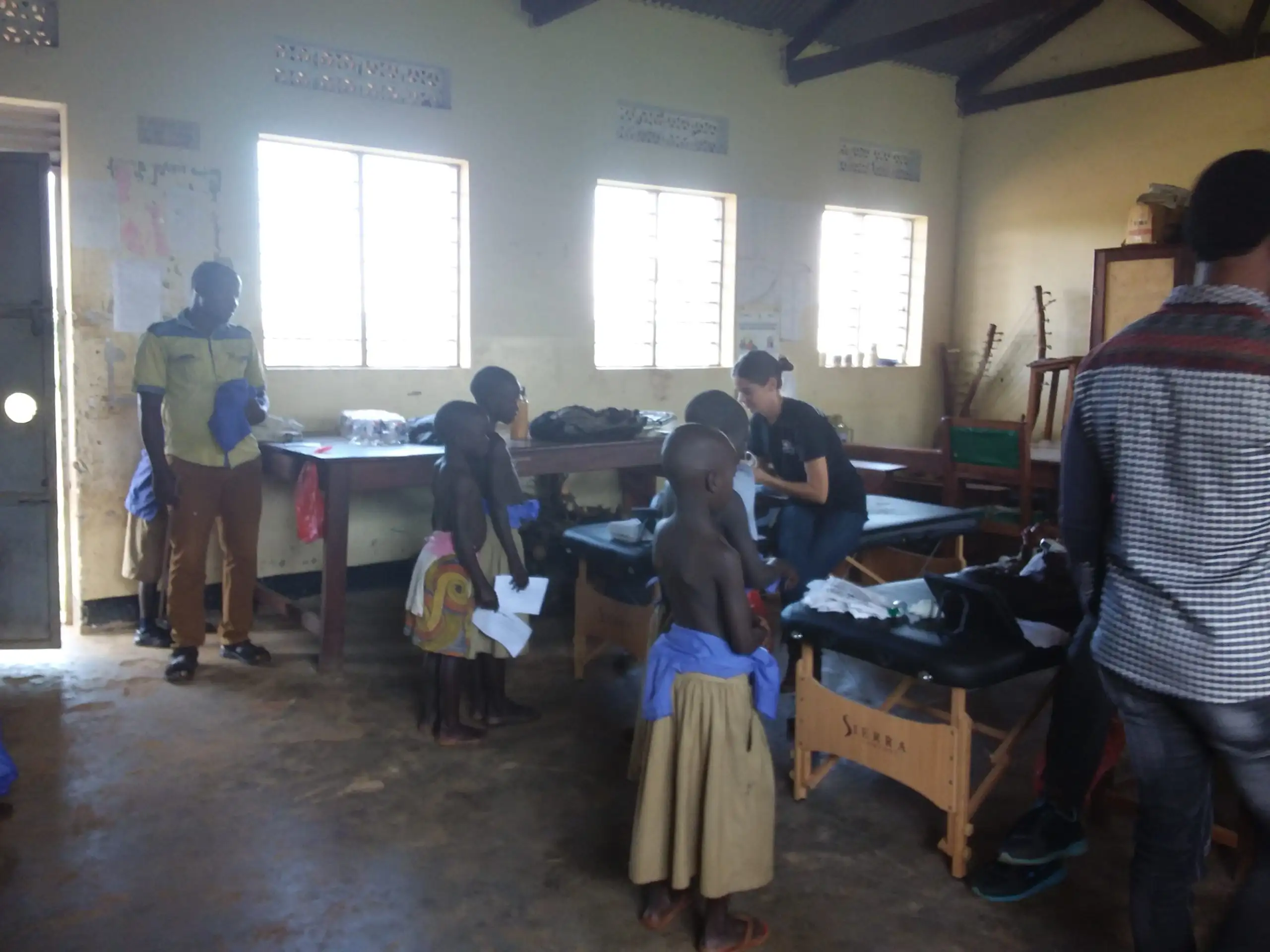 Children participating in the GOAL study lay in beds in a large, high-ceilinged room to receive exams and medications.