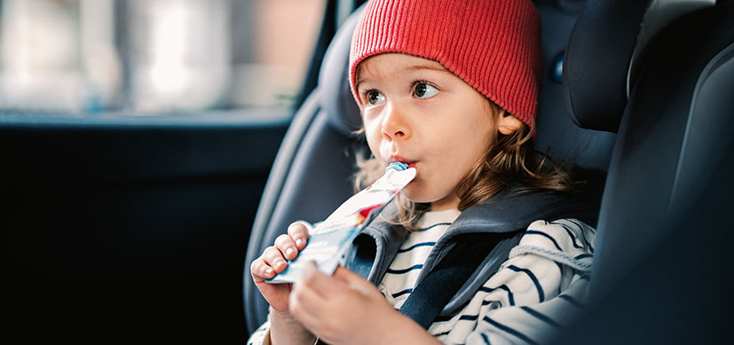 Child snacking in car seat