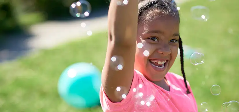 Smiling girl playing with bubbles