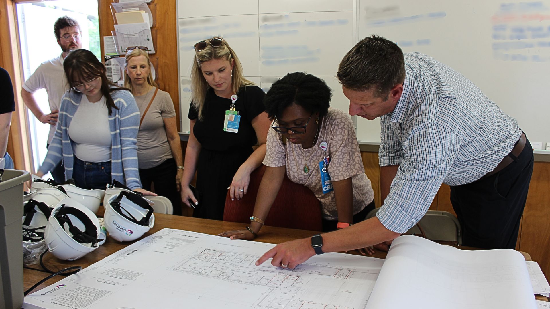 photo of Michael Pauciulo, MBA, director of the Discover Together Biobank, showing his team the building's plans.