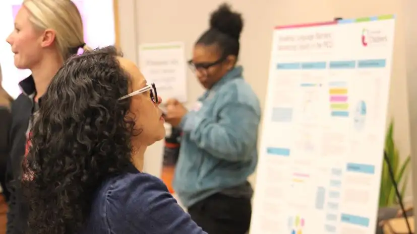 woman looks at poster presentation during excellence in child health day