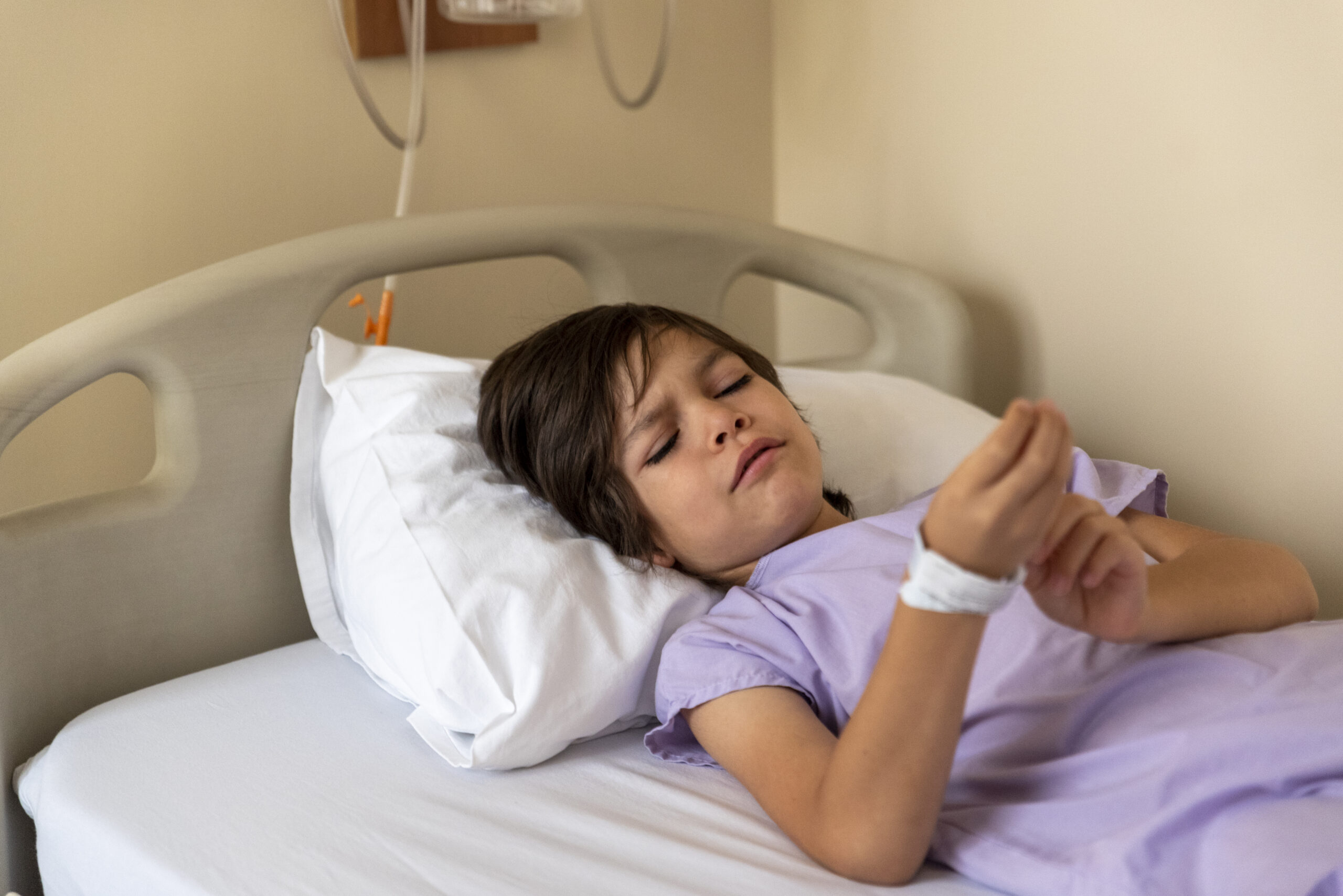 Child adjusts an identification bracelet.